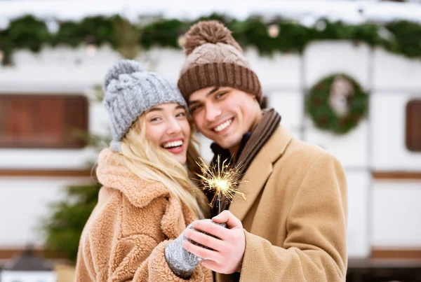 Festliche Stimmung. Romantische junge Liebhaber halten bengalisches Licht in der Hand und posieren auf einem Wintercamping — Stockfoto