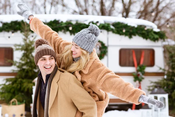 Diversión festiva. Retrato de alegre pareja joven disfrutando de la fecha en el camping de invierno —  Fotos de Stock