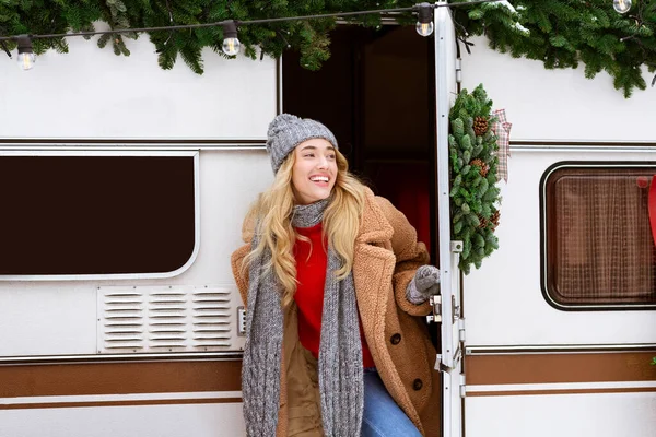 Aventura de invierno. Mujer rubia feliz abriendo puerta de autocaravana y mirando hacia el exterior —  Fotos de Stock