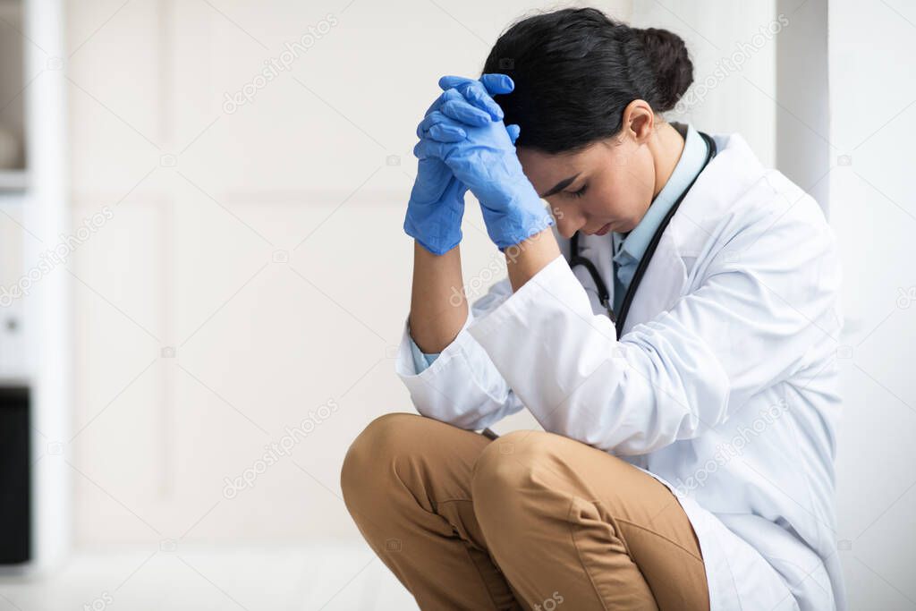 Stressed brunette woman doctor having difficult day at clinic