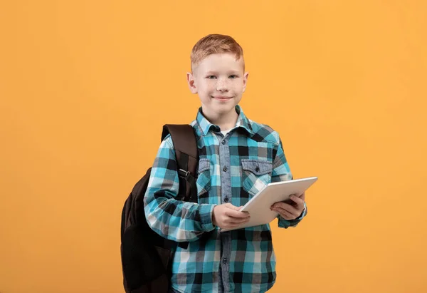 Schlauer Schuljunge mit Rucksack und digitalem Tablet — Stockfoto