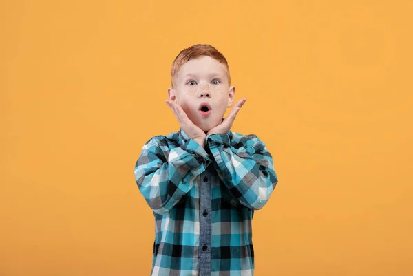 Shocked niño mantener la boca abierta y tocar la cara — Foto de Stock