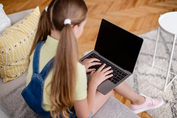 Menina usando laptop com tela de mockup em branco, digitando no teclado — Fotografia de Stock