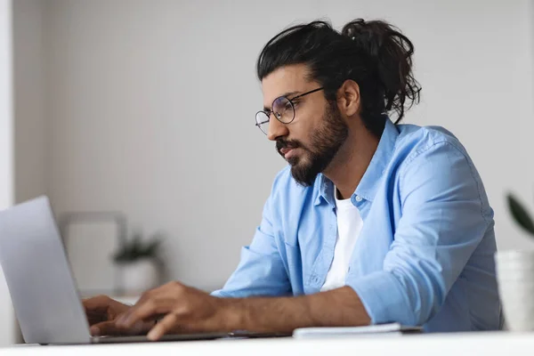 Junge westliche Mitarbeiter arbeiten am Laptop am Schreibtisch im Büro — Stockfoto