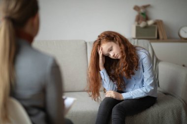 Çocuk psikoloğu. Endişeli genç kız doktorla seans yapıyor.