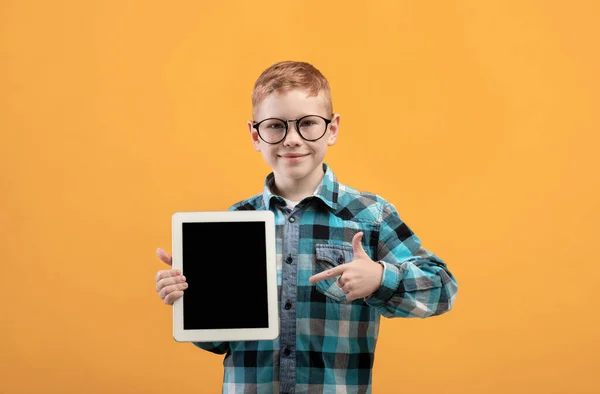 Szczęśliwy rudy chłopiec wskazując na pusty cyfrowy ekran tabletu — Zdjęcie stockowe