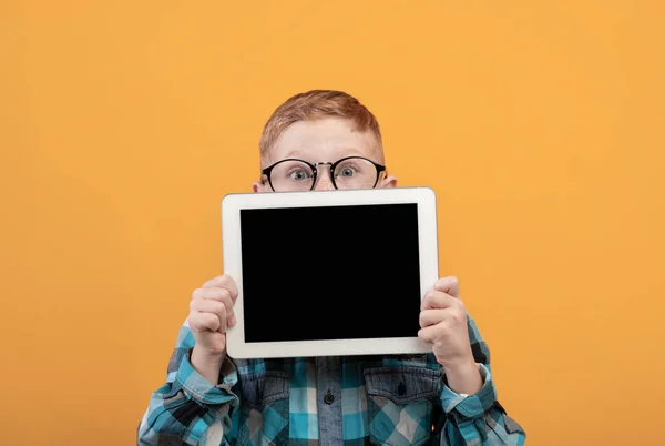 Boş ekranlı dijital tabletin arkasına saklanan hayret verici çocuk. — Stok fotoğraf