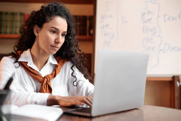 Lady sitting at desk, using computer and typing — Stock Fotó