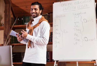 İnternette İngilizce dersi alan Hintli öğretmen bilgisayarla içeride konuşuyor.