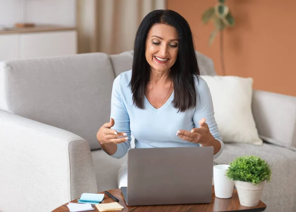 Woman sitting on couch, having video call on computer — Stock Photo, Image