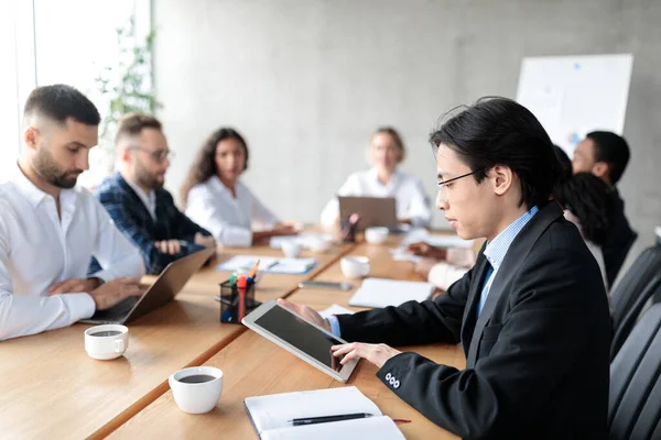 Empresario chino usando tableta digital durante reunión corporativa en oficina — Foto de Stock