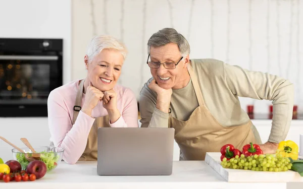 Senior Pár Sledování Online kurz vaření na notebooku v kuchyni — Stock fotografie