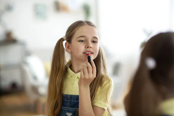 Young Girl Applying Lipstick, Looking At Mirror — стокове фото