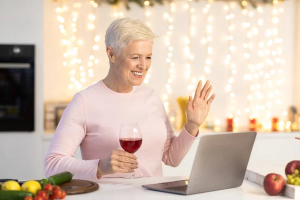 Senior frau having video call auf weihnachten sitting in kitchen — Stockfoto