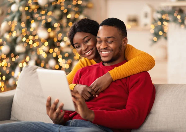 Happy millennial afrikanisch-amerikanischen Kerl und Dame umarmen und Blick auf Tablet-und Videoanruf — Stockfoto