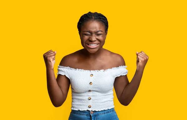 Радостная афроамериканка празднует успех и восклицает "да" с поднятыми кулаками — стоковое фото