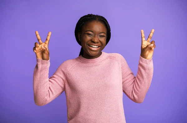 Em paz. Joyful preto jovem mulher Gesturing V-Sing e rindo sobre fundo roxo — Fotografia de Stock