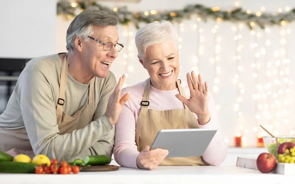 Fröhliches älteres Paar macht Videoanruf auf Tablet in Küche — Stockfoto