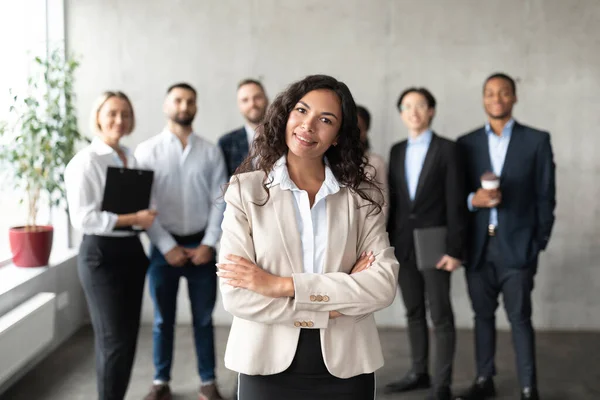 Femme d'affaires debout devant ses employés posant dans le bureau — Photo