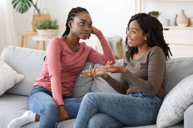 Bored black lady listening to her girlfriend, fake friendship