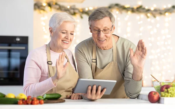 Seniorenpaar winkt dem Tablet mit Videotelefonie ins Haus — Stockfoto