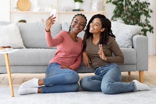 Söta svarta flickvänner tar selfie tillsammans på telefon — Stockfoto