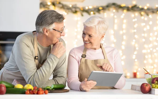 Älteres Paar bestellt mit Tablet Lebensmittel online in der Küche — Stockfoto