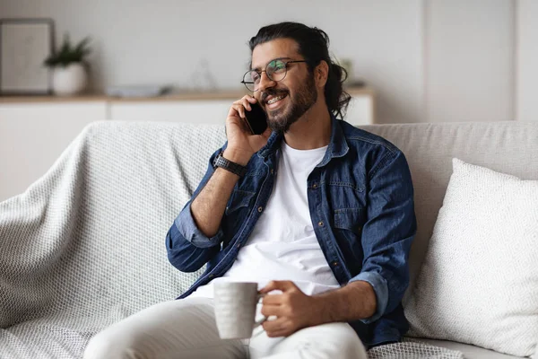 Fritid i hemmet. Indiankillen pratar med vänner och dricker kaffe hemma — Stockfoto