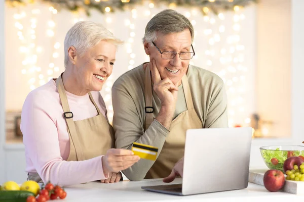 Senior-Paar mit Laptop und Kreditkarte Online-Shopping im Haus — Stockfoto