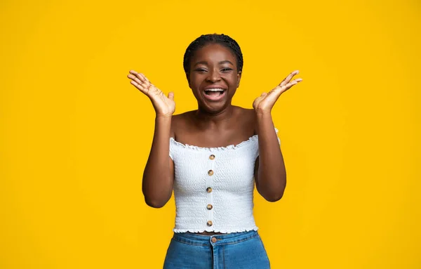 Cheerful African American Woman Laughing And Raising Hands In Excitement, Yellow Background — стоковое фото