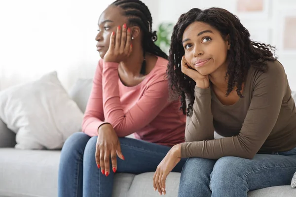 Two sad african american women sitting on sofa, had quarrel — 图库照片