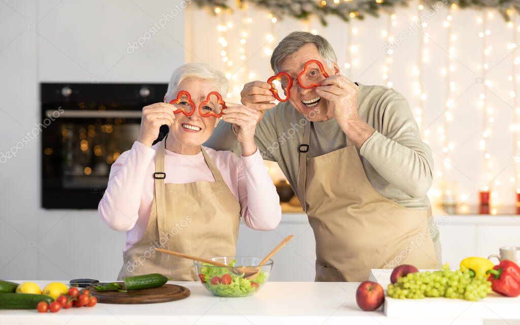 Senior Couple Having Fun Posing With Vegetables Cooking In Kitchen