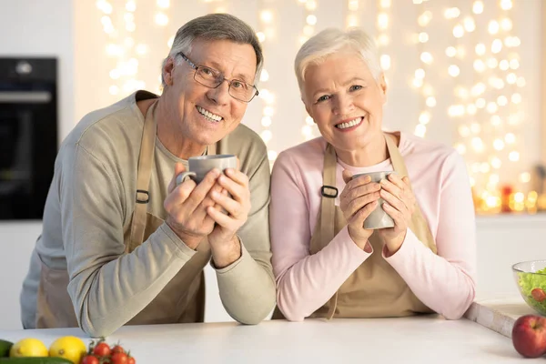 Boldog nyugdíjas pár iszik kávé ünneplő karácsony Ül a konyhában — Stock Fotó