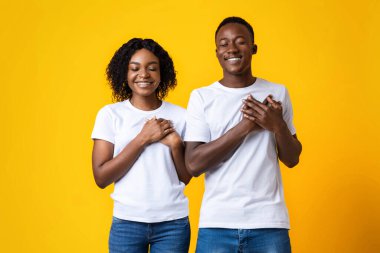 Barışçıl kadın ve erkek avuçlarını göğsünde tutuyor.