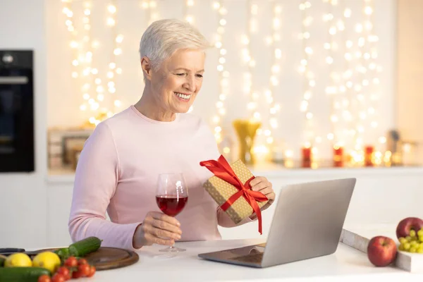 Senior lady having video call at laptop indoor auf weihnachten — Stockfoto