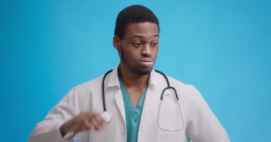 Studio portrait of disappointed african american doctor scratching his head in disbelief, has no idea what to do