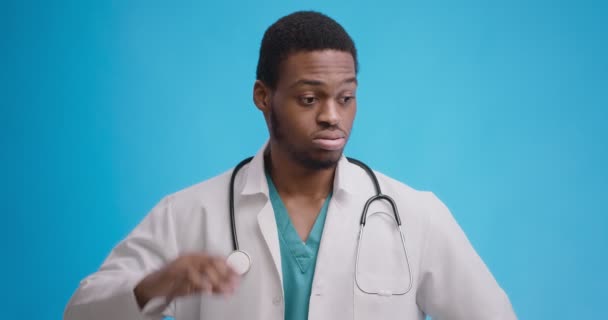 Studio portrait of disappointed african american doctor scratching his head in disbelief, has no idea what to do — ストック動画