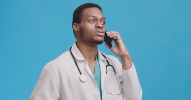 Medical doctor consulting patient via phone talk, speaking politely and friendly, blue background