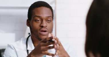 Professional medical doctor talking with patient at office, explaining risks of disease and treatment