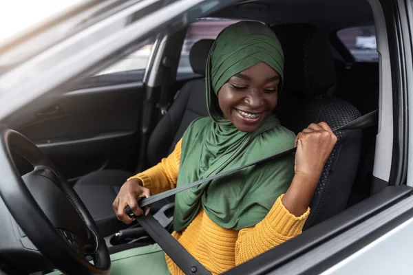 Veilig rijden. Afrikaanse vrouw in hijab zitten in auto bevestiging gordel — Stockfoto