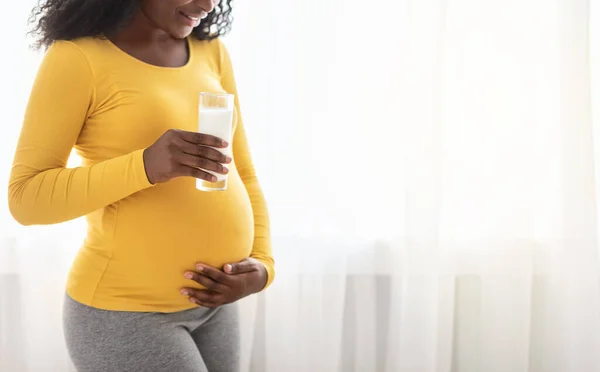 Mujer negra embarazada irreconocible sosteniendo un vaso de leche — Foto de Stock