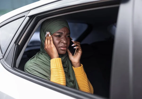 Zwarte moslim dame lijden slechte verbinding tijdens het praten op mobiele telefoon in de auto — Stockfoto