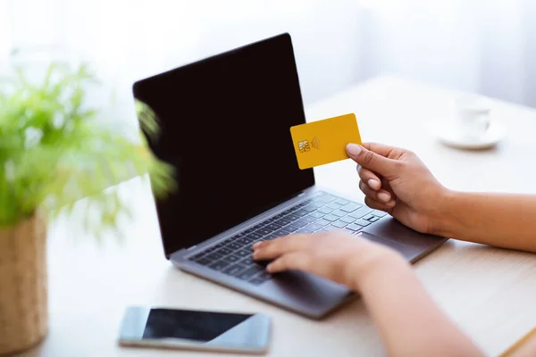 Μαύρη κυρία που χρησιμοποιεί φορητό υπολογιστή και πιστωτική κάρτα στο σπίτι — Φωτογραφία Αρχείου