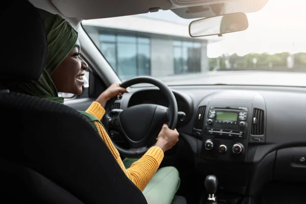 Voertuigverzekering. Gelukkig zwart moslim dame zitten op chauffeurs stoel in de auto — Stockfoto