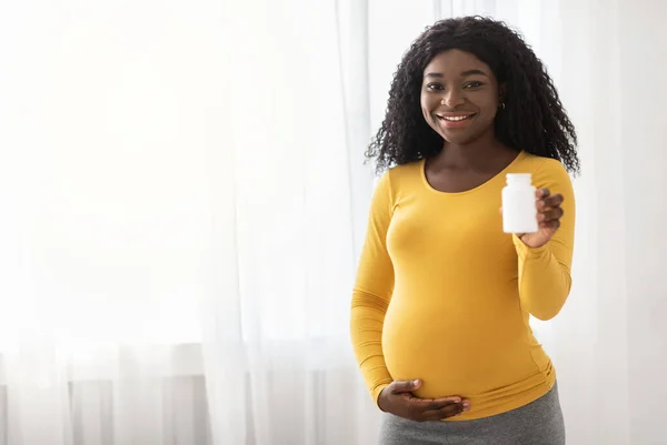 Mooie zwangere zwarte vrouw tonen haar supplementen — Stockfoto