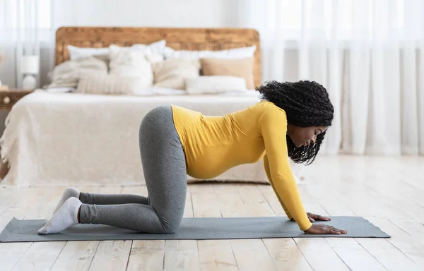Deportiva mujer embarazada negra haciendo yoga en casa — Foto de Stock