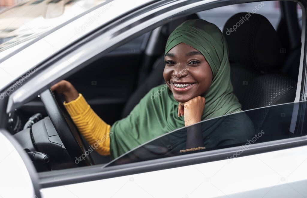 Happy Black Religious Woman In Hijab Posing Of Drivers Seat In Car