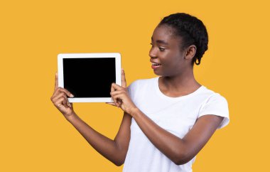 Sarı Arkaplan Üzerinde Sayısal Tablet Ekranı Gösteren Afrikalı Kadın