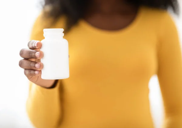 Close-up van zwarte zwangere vrouw met witte pot met medicatie — Stockfoto