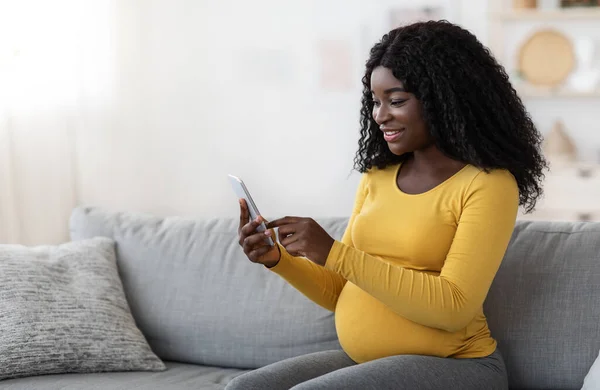 Sonriente mujer embarazada afroamericana usando teléfono móvil — Foto de Stock